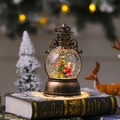 Primer plano de linterna navideña de bronce con nieve arremolinada y escena iluminada - Estilo Niños