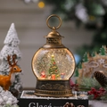 Dettaglio lanterna natalizia con Babbo Natale e neve luminosa in stile vintage - Babbo Natale con Sacco Regalo e Albero