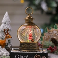 Dettaglio di una lanterna natalizia vintage in bronzo con Babbo Natale ed effetto neve - Babbo Natale in piedi