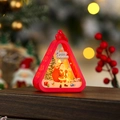 Close-up of red Christmas lantern with Santa Claus illustration on a wooden table - Red Santa Claus with Backpack