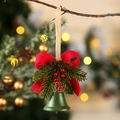 Dettaglio di campana di Natale in metallo verde con fiocco rosso e pigne su ramo - Campana verde