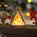 Close-up of vintage bronze Christmas lantern with snowman scene on dark wooden surface - Brushed Gold Snowman