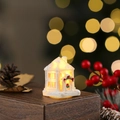 Detail van miniatuur kersthuisje in ivoor met warm LED-licht en een rode strikkrans - Stijl A (Wit 101-A)