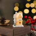 Macro shot of white resin Christmas cafe house with warm LED glow on wooden stand - Style I (White 101-I)