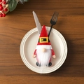 Detail of Christmas gnome cutlery holder in red knit and fur on a white dinner plate - Strap Style
