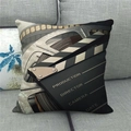 Detail of linen pillow cover with movie clapperboard and film reel print on gray sofa - Beige Film Reel Style (2)