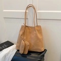 Set borsa tote in pelle opaca marrone con logo dorato e pochette su panca in pelle - Marrone