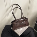 Braune rechteckige Schultertasche aus Leder mit Schnalle vor minimalistischem Hintergrund - Kaffeebraun