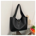 Detalle de la hebilla de bocado dorada y el cuero sintético negro mate en el bolso tote - Negro