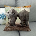 Detailed close-up of a linen rhinoceros wildlife pillow cover on a modern grey sofa - Rhinos Walking In Forest (7) / 45x45cm