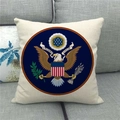 Detail eines Leinenkissenbezugs mit aufgedrucktem Adler-Emblem auf grauem Sofa - US-Wappen Muster (4)
