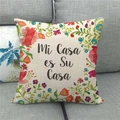 Detail of linen cushion cover with floral print and Mi Casa es Su Casa text on a grey sofa - 18x18 Inch / Mi Casa es Su Casa Hand-painted Floral Style