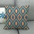 Detail eines Leinenkissenbezugs mit Retro-Geometriemuster auf einem grauen Sofa-Hintergrund - 45x45cm / Ethno-Teardrop-Muster in Petrol