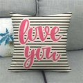 Détail de la housse de coussin en lin rayée avec texte Love You rose sur canapé - Rayures Love You (14)
