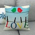 Dettaglio della federa in lino con uccelli e scritta LOVE sul divano grigio - Uccelli LOVE Cielo Blu Nuvole Bianche