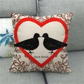 Dettaglio di un cuscino in lino con cuore e uccellini su un divano grigio di casa - love birds Cuore Rosso Due Uccelli Voluta Vintage