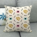 Detail van linnen kussenhoes met Made With Love tekst en glitterhartjes op een grijze bank - Made with Love Print(1)