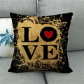 Detail eines Leinenkissenbezugs mit goldenem LOVE Text und rotem Herz auf grauem Sofa - Schwarzer Hintergrund Gold LOVE (4)