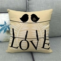 Close-up of linen pillowcase featuring birds and LOVE text on a grey fabric sofa - Double Birds Leaf LOVE (10)