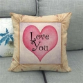 Close-up of linen pillowcase with Love You print and pink heart on a grey sofa - Cross Stitch Border Pink Heart (18)