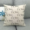 Close-up of linen cushion cover featuring black cursive L'amour print on grey sofa - French L'amour Art Style (13)