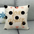 Close-up of Love Always printed linen pillowcase with black polka dots on a sofa - Golden Love Always (13)