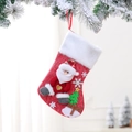 Dettaglio calza di Natale con Babbo Natale e targhetta in legno su un ramo innevato - Babbo Natale