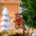 Λεπτομέρεια από ρητινένιο ανθρωπάκι gingerbread με κόκκινο καπέλο σε Χριστουγεννιάτικο δέντρο - Στυλ Κόκκινος Φιόγκος