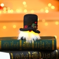 Gnomo de Navidad con luz y sombrero negro con piña sobre libros de estilo retro - Estilo de sombrero negro