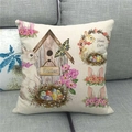 Easter linen pillow cover with bunnies and birdhouse on a gray fabric sofa - 45x45cm / Wooden Birdhouse Bunny Style (6)