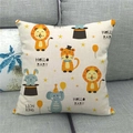 Dettaglio del cuscino in lino con motivi animali e testo Hello Baby sul divano grigio - Combinazione Leone Tigre Coniglio Elefante