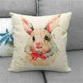 Detail of square linen pillowcase with watercolor bunny and red bow on a gray sofa - Off-white Watercolor Rabbit with Red Bow