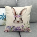 Funda de cojín de lino con conejo de Pascua y corona floral en sofá gris - Watercolor Wreath Bunny