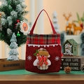 Close-up of a festive red Christmas gift bag with a snowman applique and plaid trim - Snowman