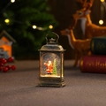 Macro-opname van een bronzen kerstwaterlantaarn met kerstman en glinsterende sneeuw - Platte Lamp Kerstman (Watergevuld)