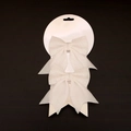 Detail view of two white glitter Christmas bows on a hanging display card for tree decor - White