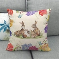 Detail van de linnen kussensloop met paashaasjes, lelies en vlinderprint op de bank - Konijnenfamilie Bloemen Stijl (2)