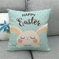 Funda de cojín de lino Felices Pascuas con conejo y lunares azules en un sofá - 45x45cm