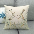 Close-up of linen pillowcase featuring watercolor rabbits on a gray sofa - Rabbits in Grass (7)