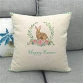 Leinen Oster-Kissenhülle mit Hasenmotiv und Blumenkranz auf einem grauen Sofa - Grüner Karorand Hase Blumen Stil (3)