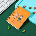 Details eines orangefarbenen Weihnachtsnotizbuchs mit Rentier- und Lebkuchen-Illustrationen - Gelbes Reh
