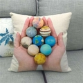 Detail of linen cushion cover showing planet print on a gray fabric sofa - Hand Holding Planet (16)