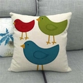 Detailed view of square linen pillow cover featuring three cute cartoon birds on sofa - Three Cartoon Red Green Blue Birds (1)