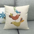 Detail of a square linen cushion cover with colorful cartoon birds on a grey sofa - Blue Bird with Flower Branch Stack (15)