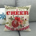 Linnen kussensloop met aquarel bloemen en kersttekst op een grijze stoffen bank - Spread Holiday Cheer Bloemen (3)
