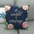 Detail van linnen kussensloop met bloemenprint en tekst op een grijze bank - The World Is Waiting Donkerblauw (4)