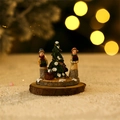 Close-up of miniature Christmas figures and snowy tree on wood base with bokeh lights - Figure with Christmas Tree (Figure Type F)