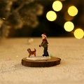 Close-up of a Christmas boy and puppy miniature figurine on snow base with bokeh light - Boy with Dog (Figure Type G)
