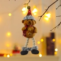 Dettaglio dell'orso di peluche natalizio con sciarpa e perline di legno su un ramo - Orso