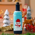 Détail de la housse de bouteille de vin tricotée avec motif bonhomme de neige et décor festif - Bonhomme de neige